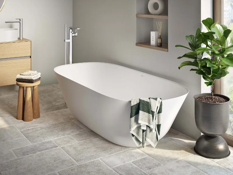 Ein modernes Badezimmer mit einer weißen Theano Badewanne von Villeroy & Boch und einer Pflanze.