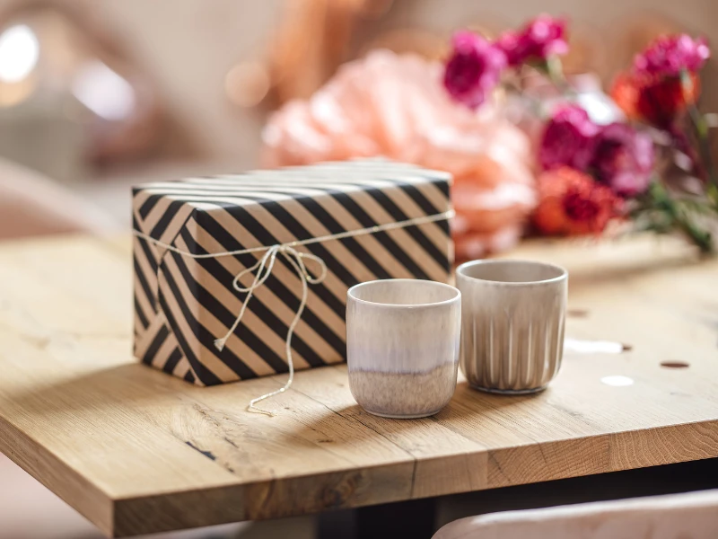 Two Perlemor mugs in beige from like. by Villeroy & Boch as a gift in brown and black gift packaging.