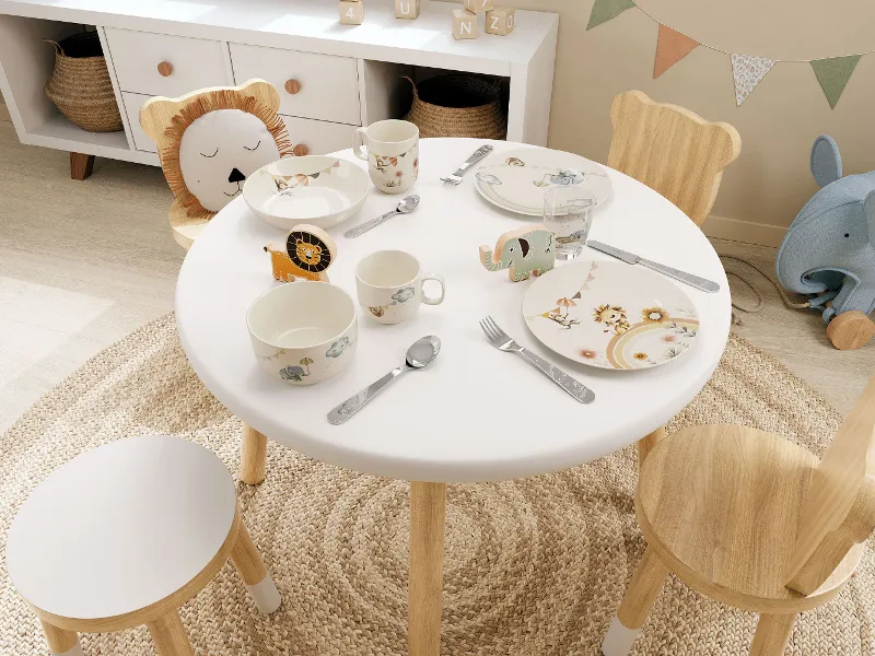 Een gedekte tafel in de kinderkamer met Boho-Kids servies, bestek en glazen in een dierenthema in pastelkleuren.