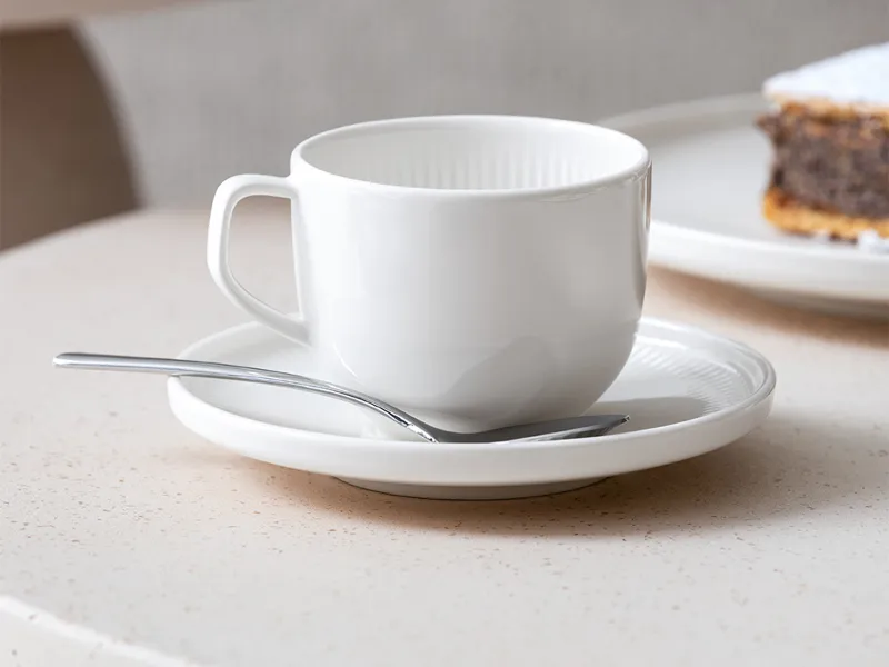 Gros plan sur la tasse à café Afina et sa sous-tasse, pour mettre en valeur l’impression de flottement dans l’air.