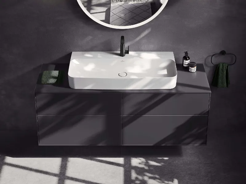 Bagno total black con doccia vetrata, WC "Antao" nero, mobile lavabo "Antao" a parete con lavabo da appoggio "Loop & Friends", specchio e finestra che lascia entrare la luce naturale.