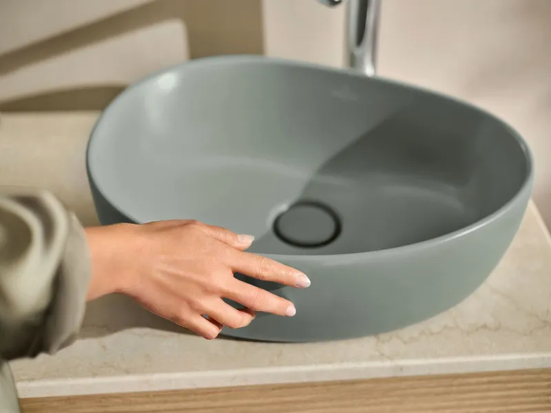 Eine Hand berührt ein freistehendes Waschbecken der Badkollektion Antao von Villeroy & Boch.