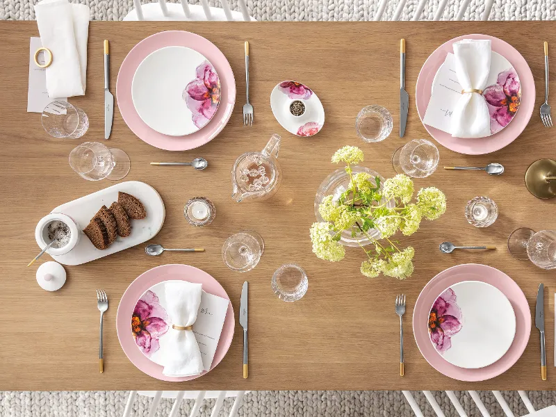 Et dekket bord med rosa og hvite tallerkener og bestikk fra Rose Garden-kolleksjonen til Villeroy & Boch.