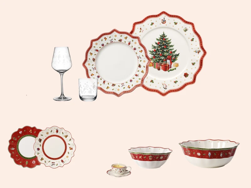 Christmas tableware set with plates bowls utensils and glasses decorated with red accents and a decorated tree