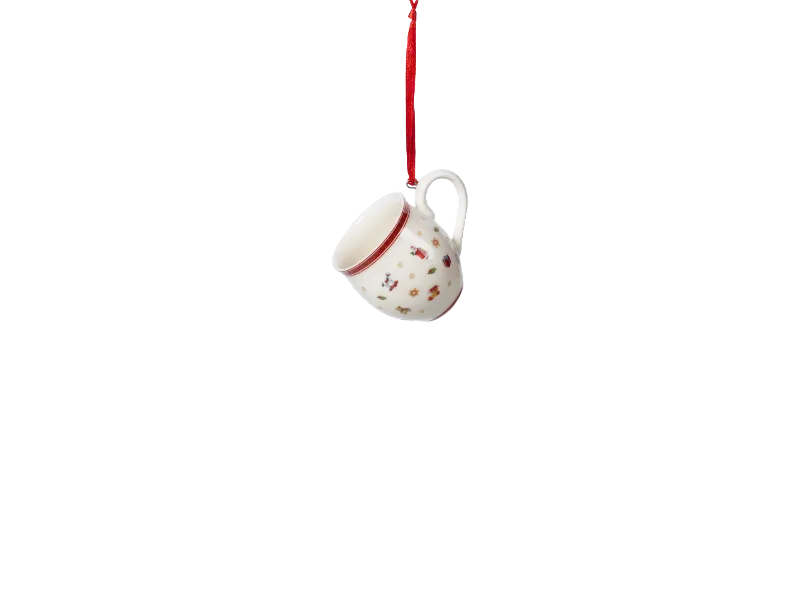 Ein weißer Becher mit Weihnachts-Muster hängt an einem roten Band.