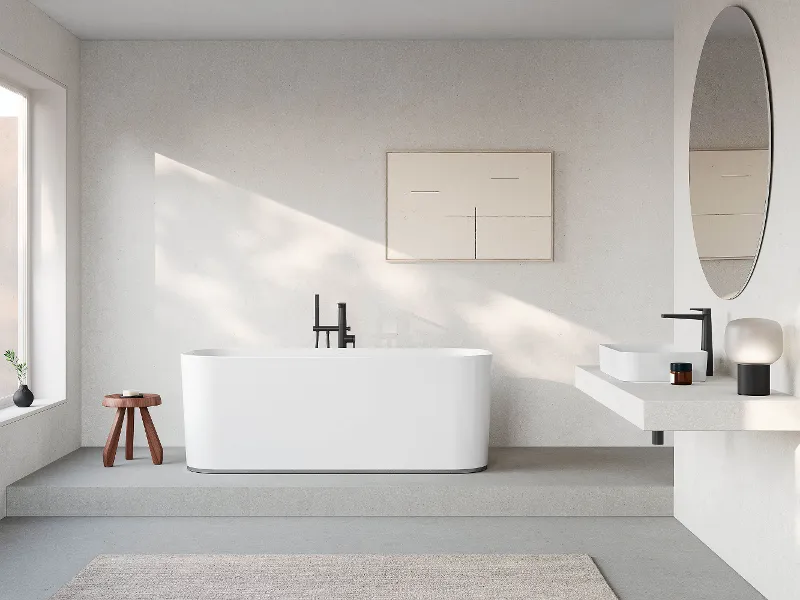 Minimalistisches Badezimmer mit freistehender Badewanne, Holzhocker, wandmontiertem Waschbecken mit schwarzem Wasserhahn, rundem Spiegel und gerahmter Kunst.