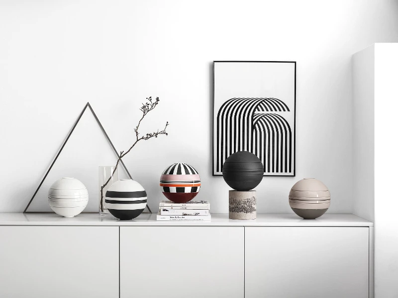 A white shelf with several La Boule dinnerware sets on top.