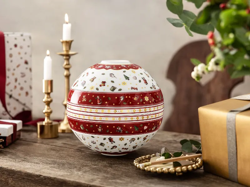 Toy's Delight La Boule on a wooden table surrounded by candles, presents and a pine cone.