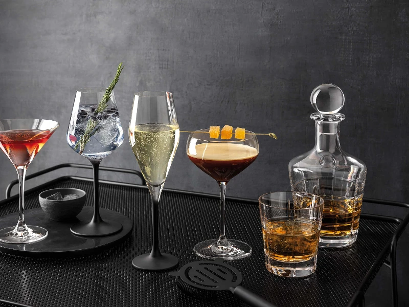 A black tray with several drinks in Manufacture glasses and an Ardmore whisky decanter on top.