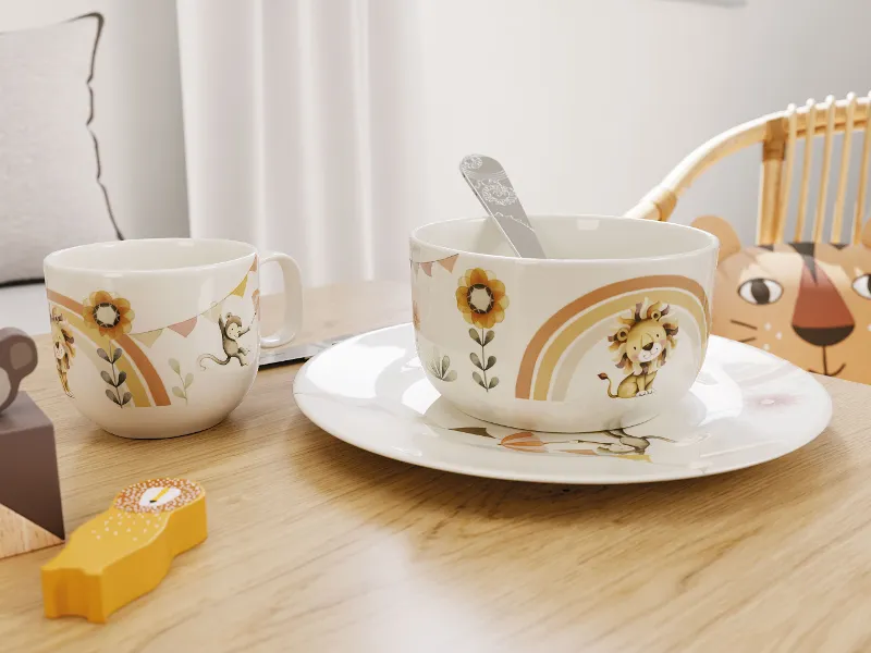 Dinnerware set by Villeroy & Boch 'Boho Kids | Roar like a Lion' with lion motifs – cup, bowl, plate, and spoon displayed on a table.