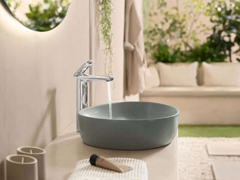 Un lavabo verde della collezione Antao di Villeroy & Boch con un rubinetto in funzione.