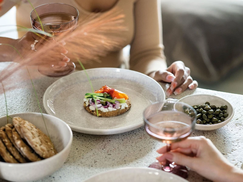 A group of people sitting at a table and eating crisp bread on Perlemor plates.