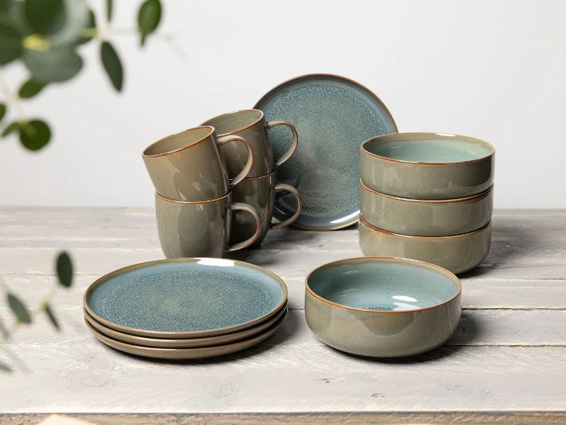 A set of turquoise Crafted dinnerware from like. by Villeroy & Boch stacked on a table.