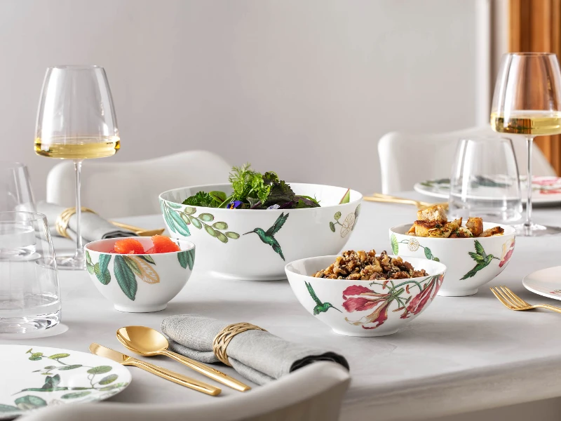 Une table de salle à manger élégamment dressée avec de la vaisselle Avarua et des verres MetroChic contenant du vin blanc.