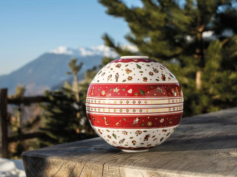 La Boule Toy’s Delight posée sur une table en bois avec des montagnes en arrière-plan.