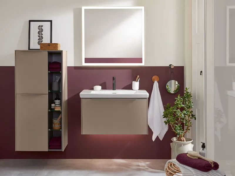 Une salle de bains avec un lavabo Subway 3.0, un miroir, une armoire et un mur rouge.