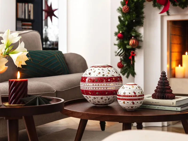 Un salon décoré pour Noël avec La Boule Toy’s Delight et La petite Boule Toy’s Delight sur une table basse en bois.