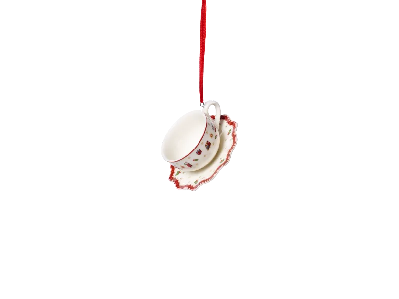 Eine Teetasse und eine Untertasse mit Weihnachts-Muster hängen an einem roten Band.