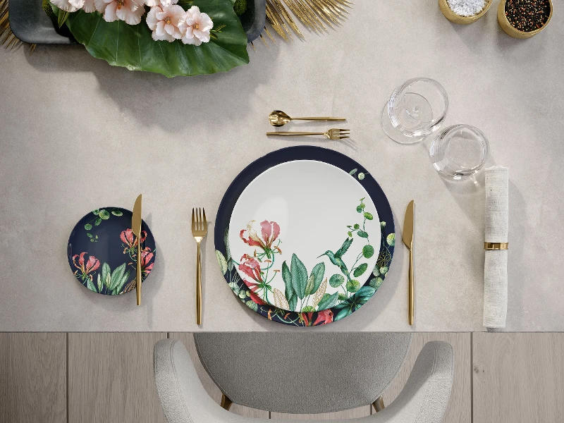 A table setting with floral pattern dinnerware from Avarua and golden MetroChic flatware.