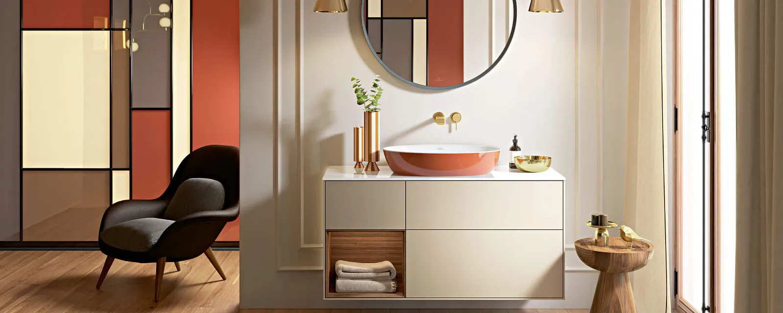 Orangenes Artis Waschbecken auf Finion Unterschrank Modernes Badezimmer mit orangefarbenem Artis Waschtisch, rundem Spiegel, beigem Finion Unterschrank und minimalistischem Dekor