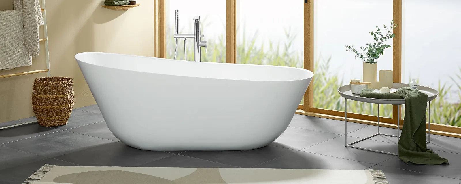 Una vasca da bagno Theano freestanding bianca nel bagno Villeroy & Boch con un'ampia finestra frontale.