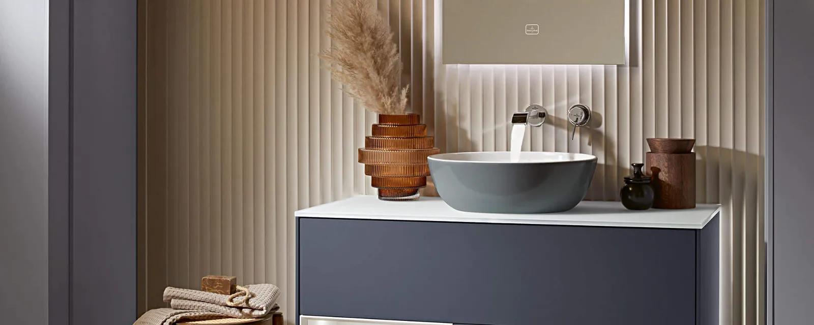 Un lavabo Artis French Linen sur un meuble sous plan gris Un lavabo Artis sur un meuble sous plan gris et un miroir lumineux dans une salle de bains.