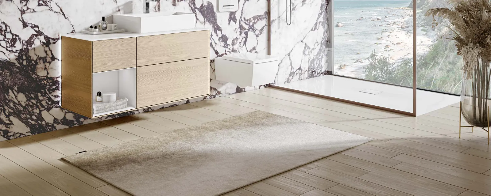 Une salle de bains complète dans des tons naturels avec de la céramique Memento 2.0 blanche Une salle de bains moderne avec de la céramique blanche et des tons naturels signée Villeroy & Boch, des éléments en bois et grande baie vitrée offrant une vue sur la mer.