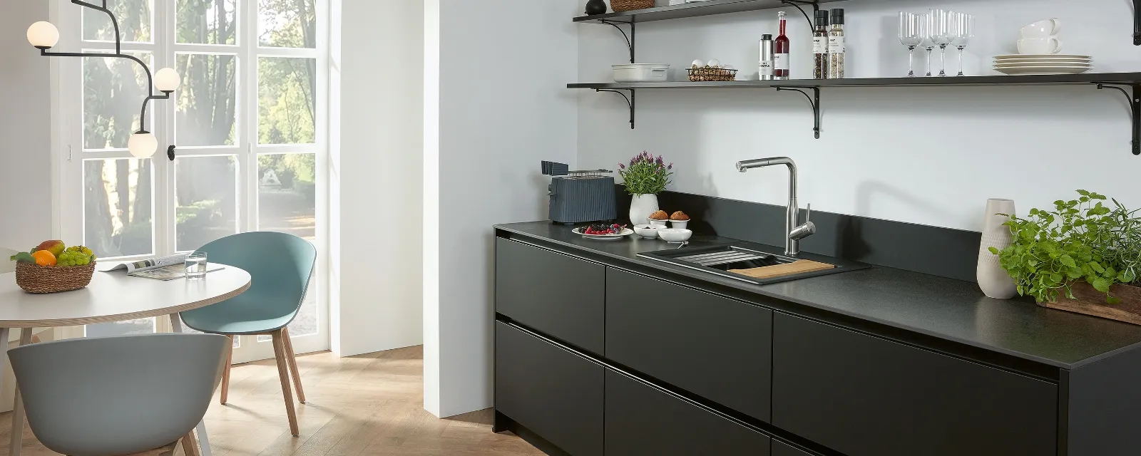 Subway Style Shower Küchenarmatur in schwarzer Küche Eine Subway Style Shower Küchenarmatur edelstahl massiv in einer schwarze Küche mit Regalen und Spüle.