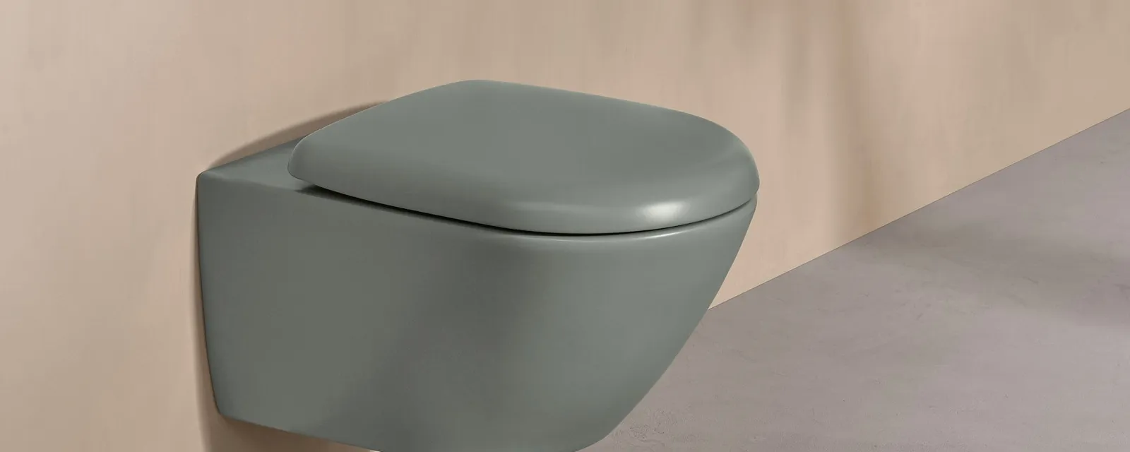 WC Antao grün mit weißer Drückerplatte Ein Villeroy & Boch WC der Antao Kollektion grün mit weißer Steuerungsplatte an einer Wand in Naturton.