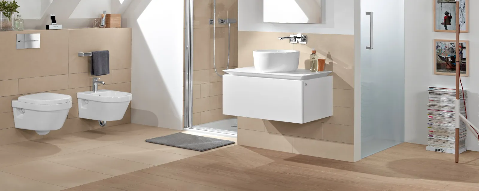 Une salle de bains moderne avec des WC et un bidet suspendus Architectura, un plan de toilette suspendu avec un lavabo et un miroir, une douche vitrée, une lucarne et une lampe.