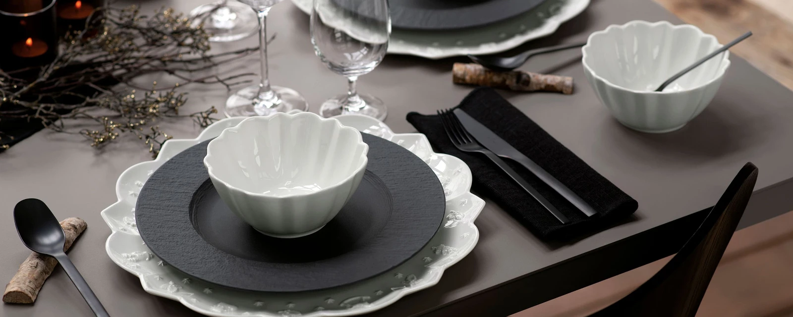 A table set with black Manufacture plates and white Toy’s Delight dinnerware from Villeroy & Boch.