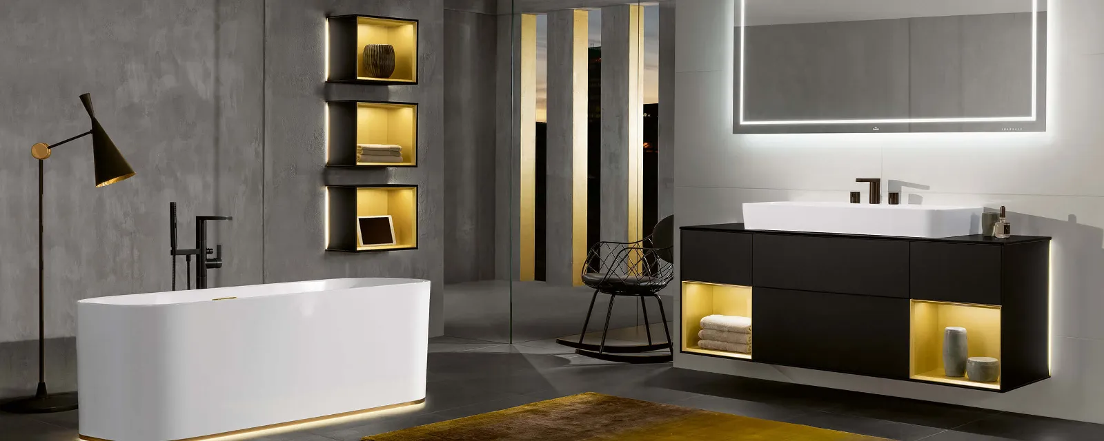 Weiße Finion Badewanne mit Beleuchtung Eine weiße Finion Badewanne in modernem, grauem Badezimmer mit Beleuchtung.