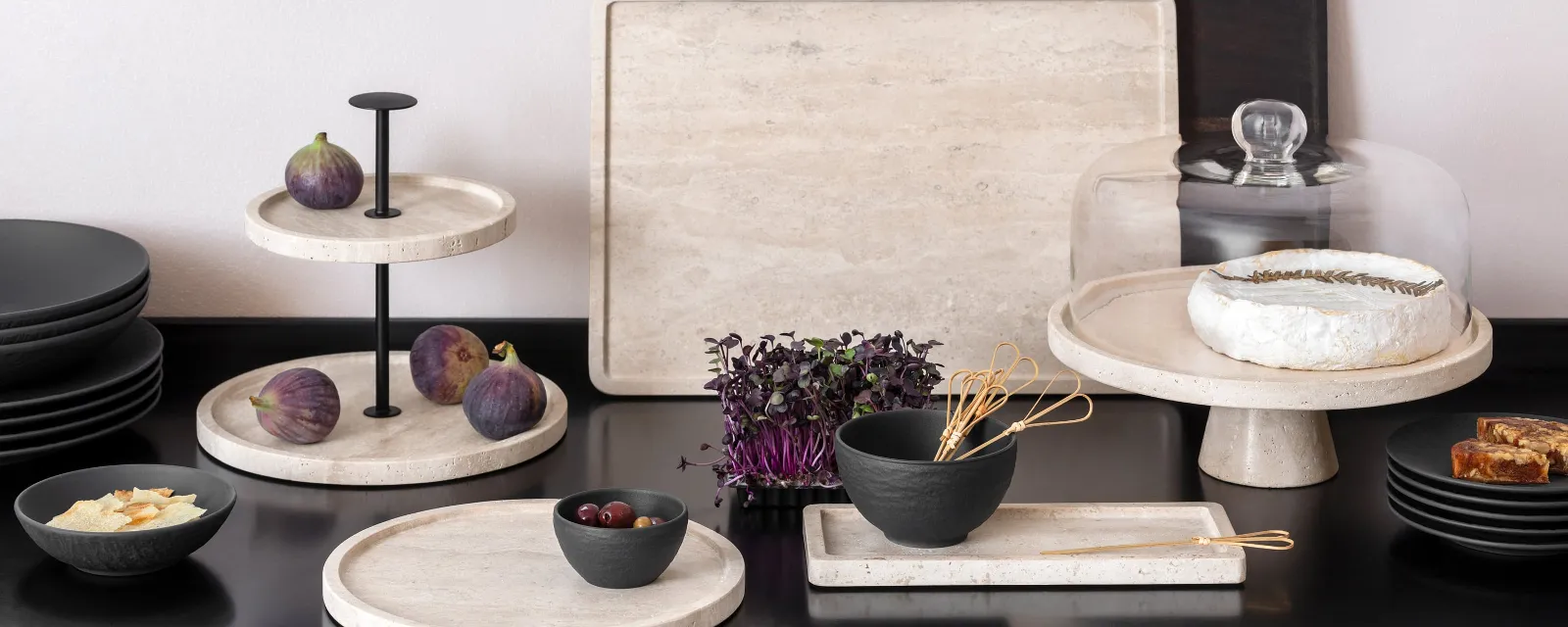Manufacture Travertin and Manufacture skilfully staged Kitchen countertop with elegant Manufacture Travertine trays, on which figs, brie, bread and a bowl of vegetables are presented.
