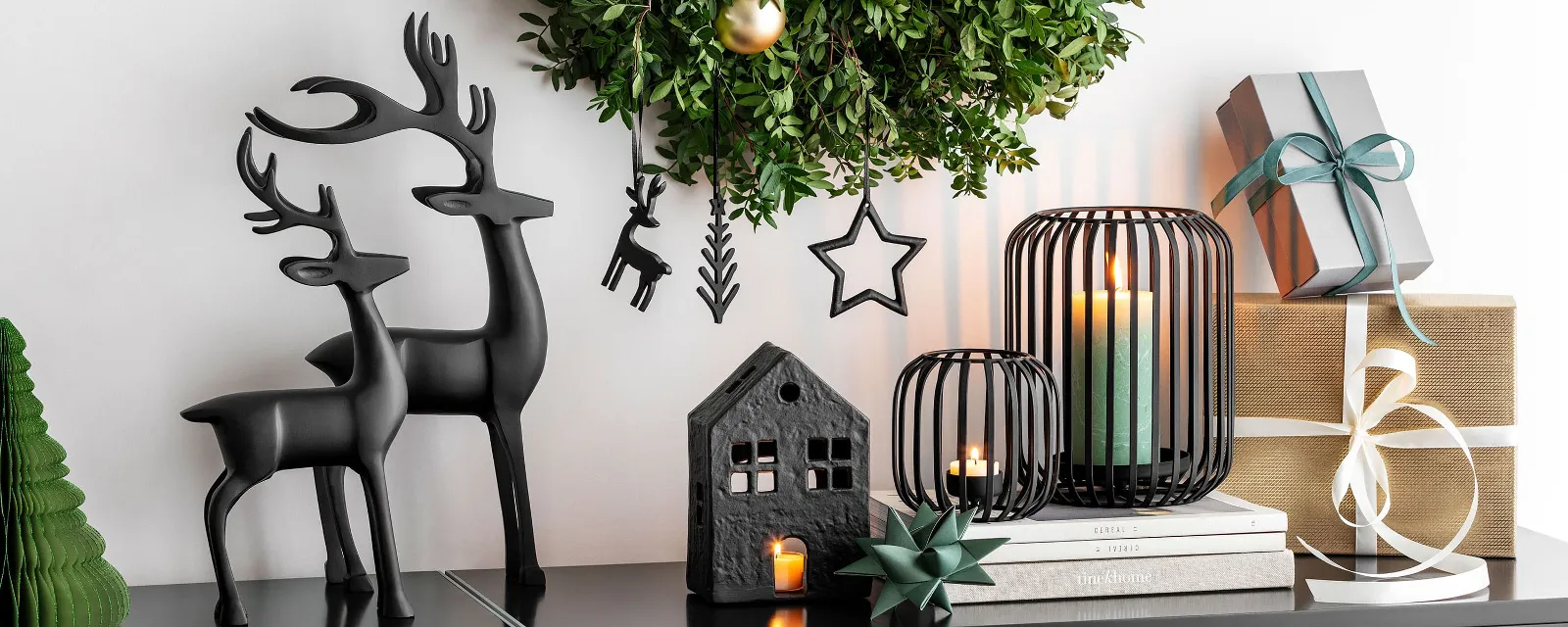 Moderne Black XMAS kerstdecoratie met een groene krans op een schoorsteenmantel.