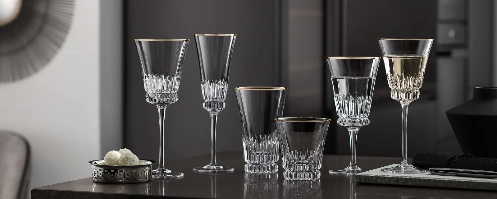 Elegant Grand Royal glasses on a counter in a modern kitchen with dark cupboards in the background.