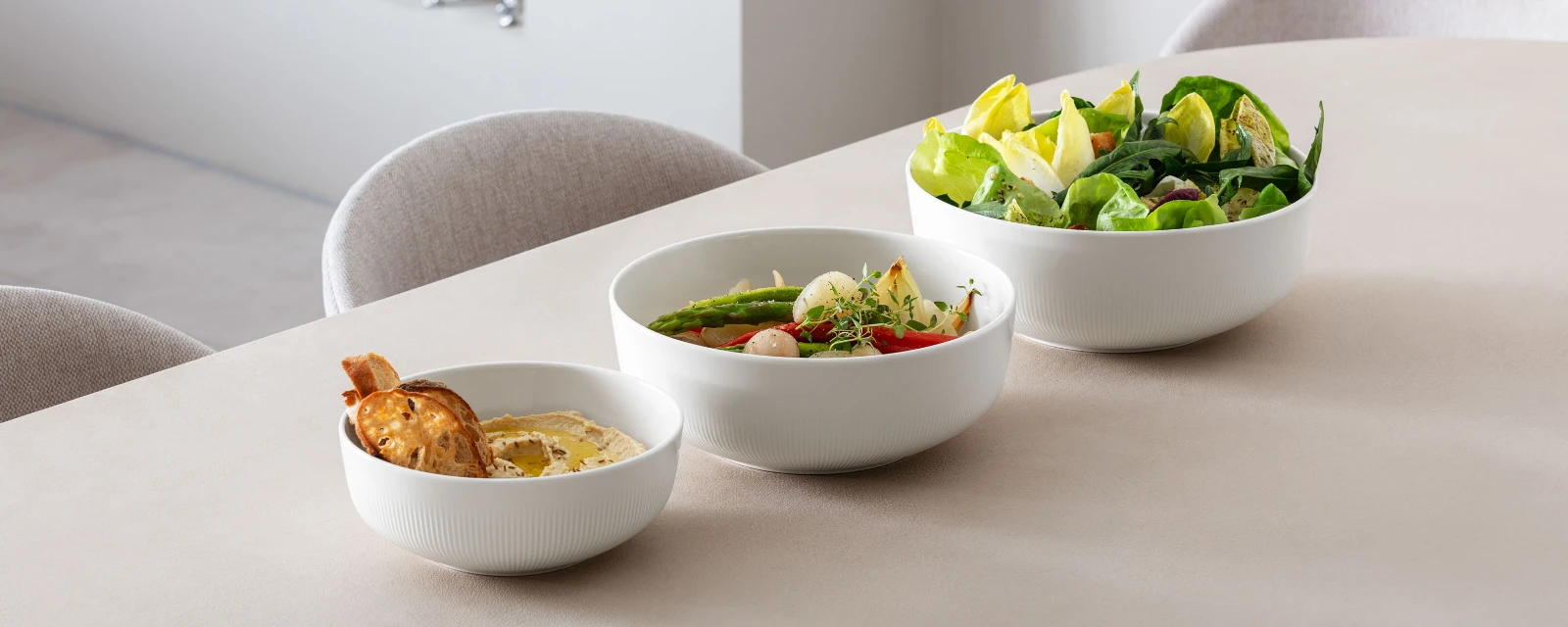 Afina serving bowls in three different sizes, filled with different dishes.