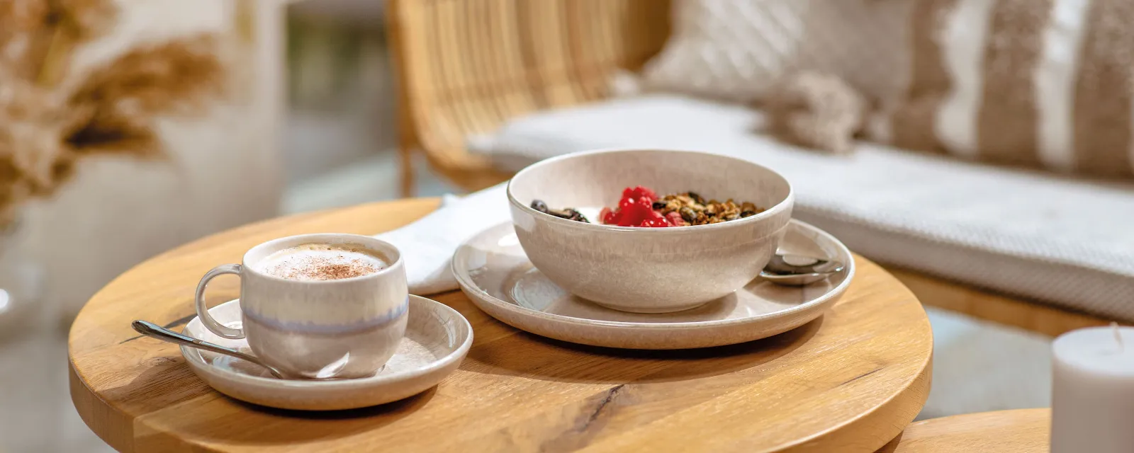 Een Perlemor kopje met koffie en een kom met muesli op een houten tafel.