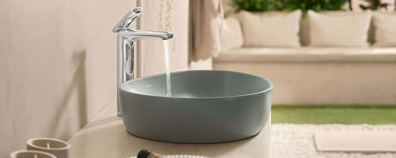 Un lavabo verde della collezione Antao di Villeroy & Boch con un rubinetto in funzione.