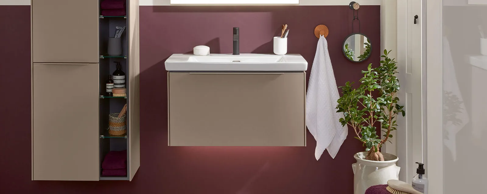 Une salle de bains avec un lavabo Subway 3.0, un miroir, une armoire et un mur rouge.