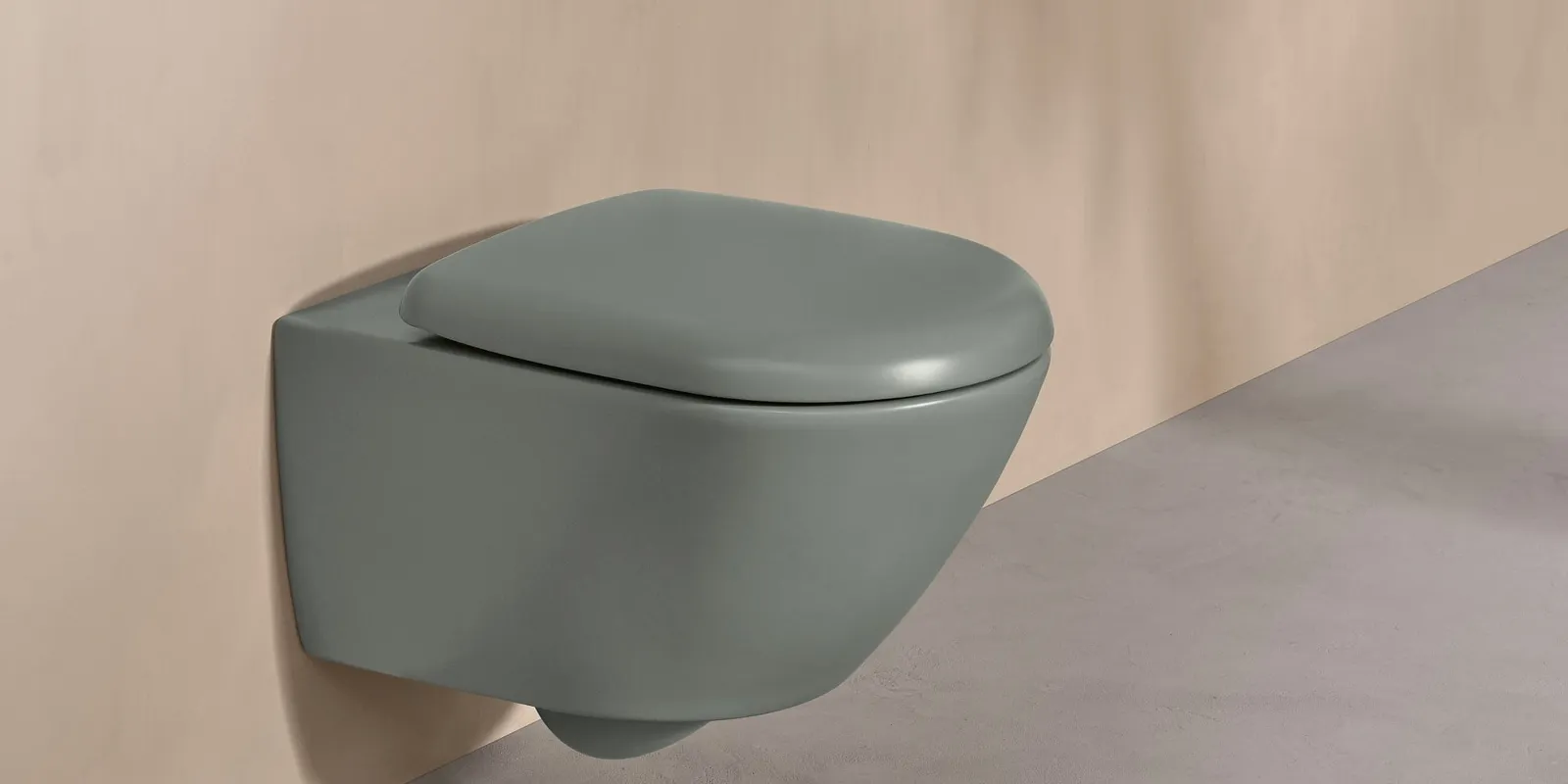 Des WC Villeroy & Boch de la collection Antao verts avec une plaque de déclenchement blanche sur un mur dans un ton naturel.