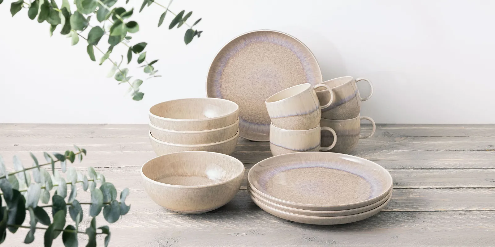 Un set di stoviglie beige Perlemor di like. by Villeroy & Boch impilate su un tavolo.