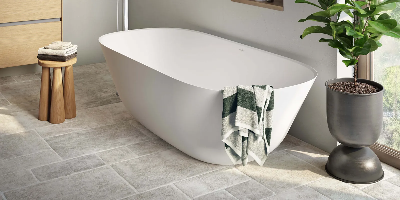 Une salle de bains moderne avec une baignoire blanche Theano de Villeroy & Boch et une plante.