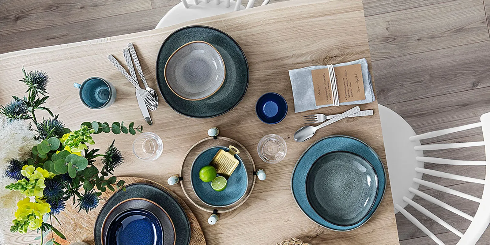 Une table en bois avec des assiettes Lave de Villeroy & Boch posées dessus.