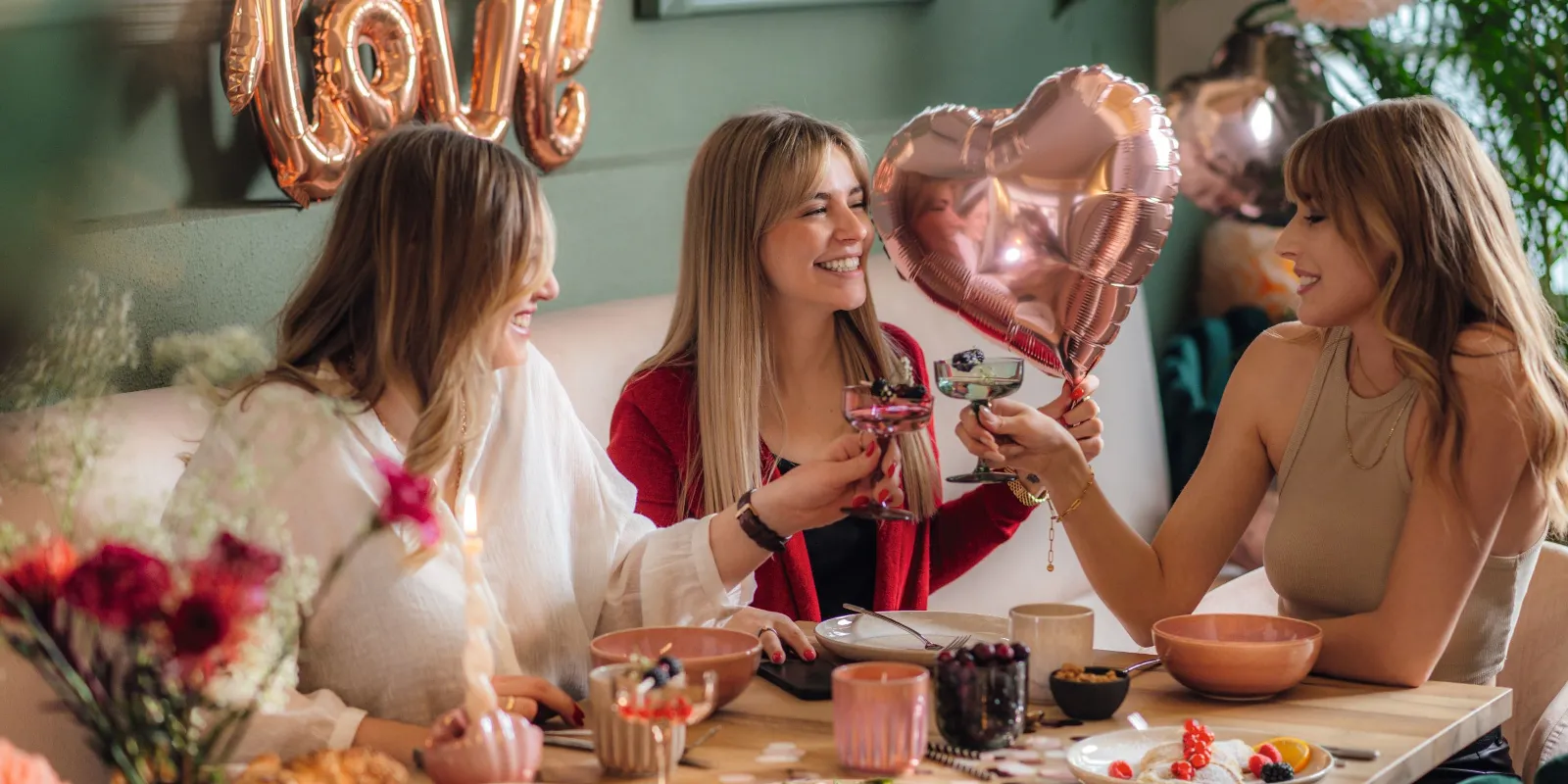 women having a valentine's day lunch with balloons that are heart shaped 