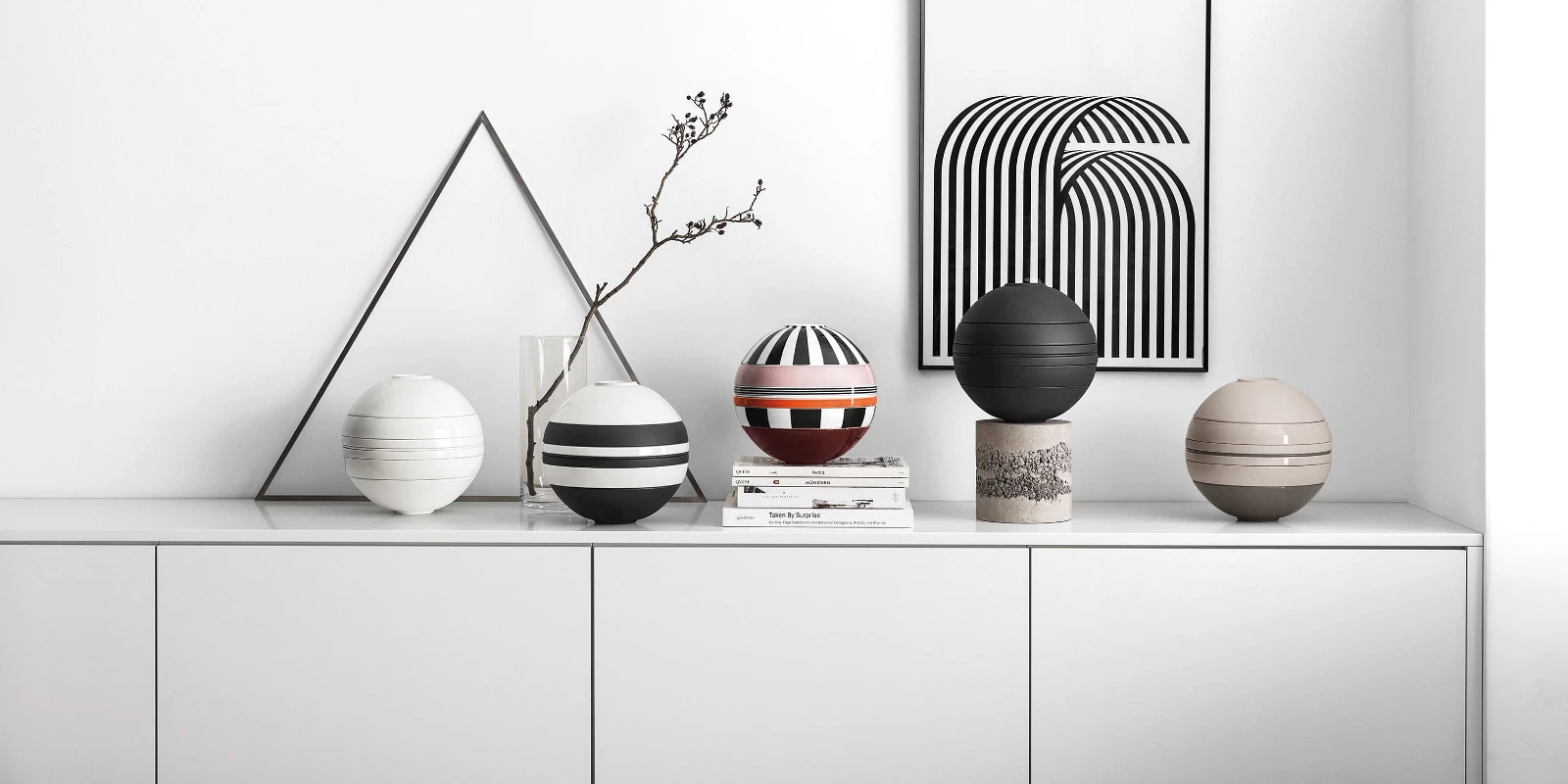 A white shelf with several La Boule dinnerware sets on top.