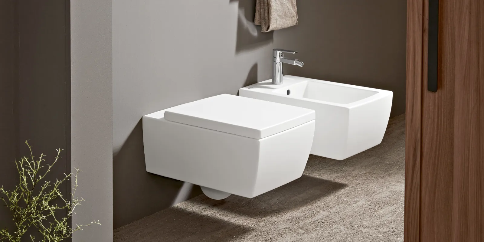 Moderne weiße Memento 2.0 Toilette und Bidet im minimalistischen Design in naturfarbenem Bad