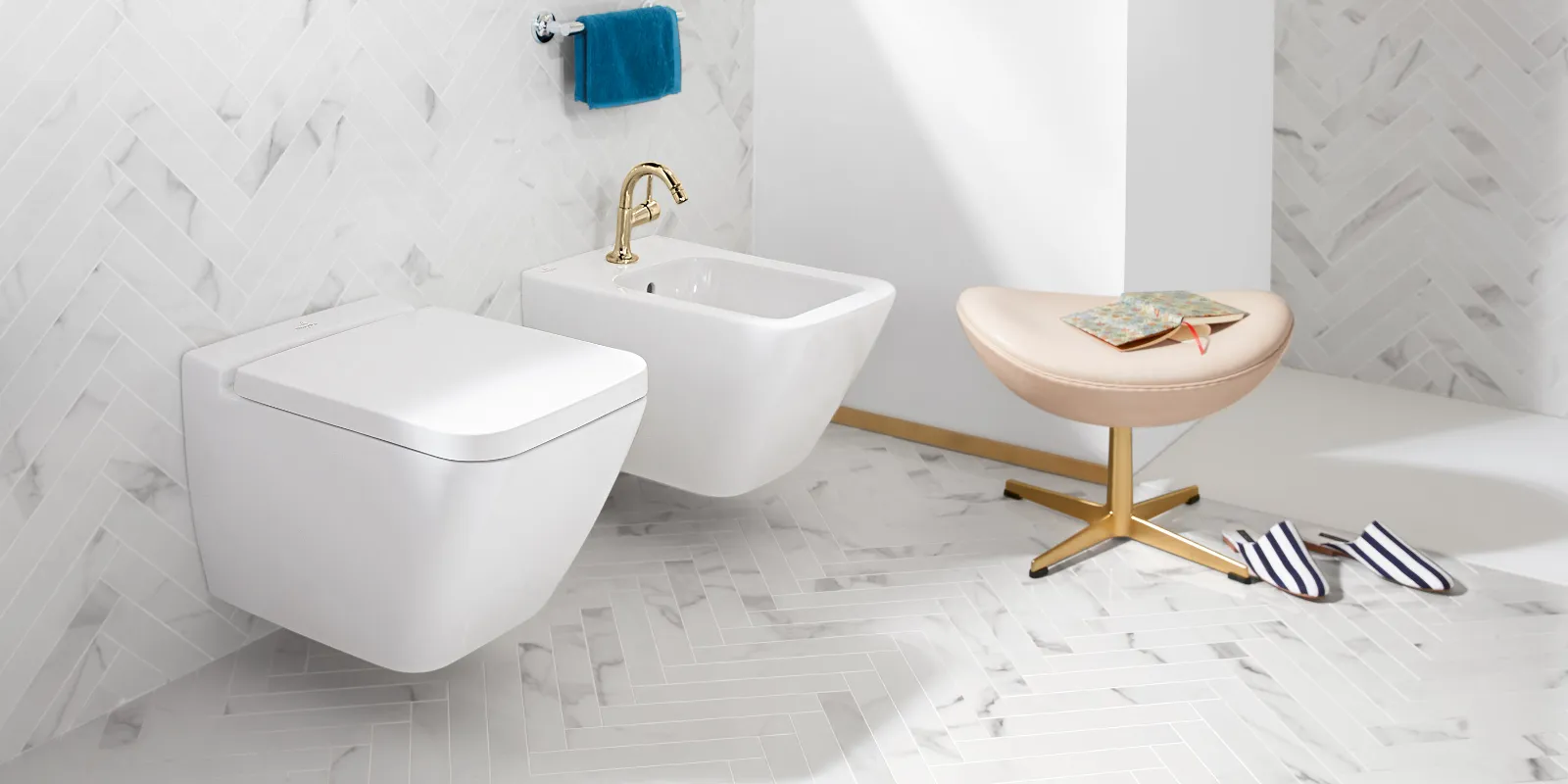 WC e bidet Finion bianchi di Villeroy & Boch con sgabello e pantofole.