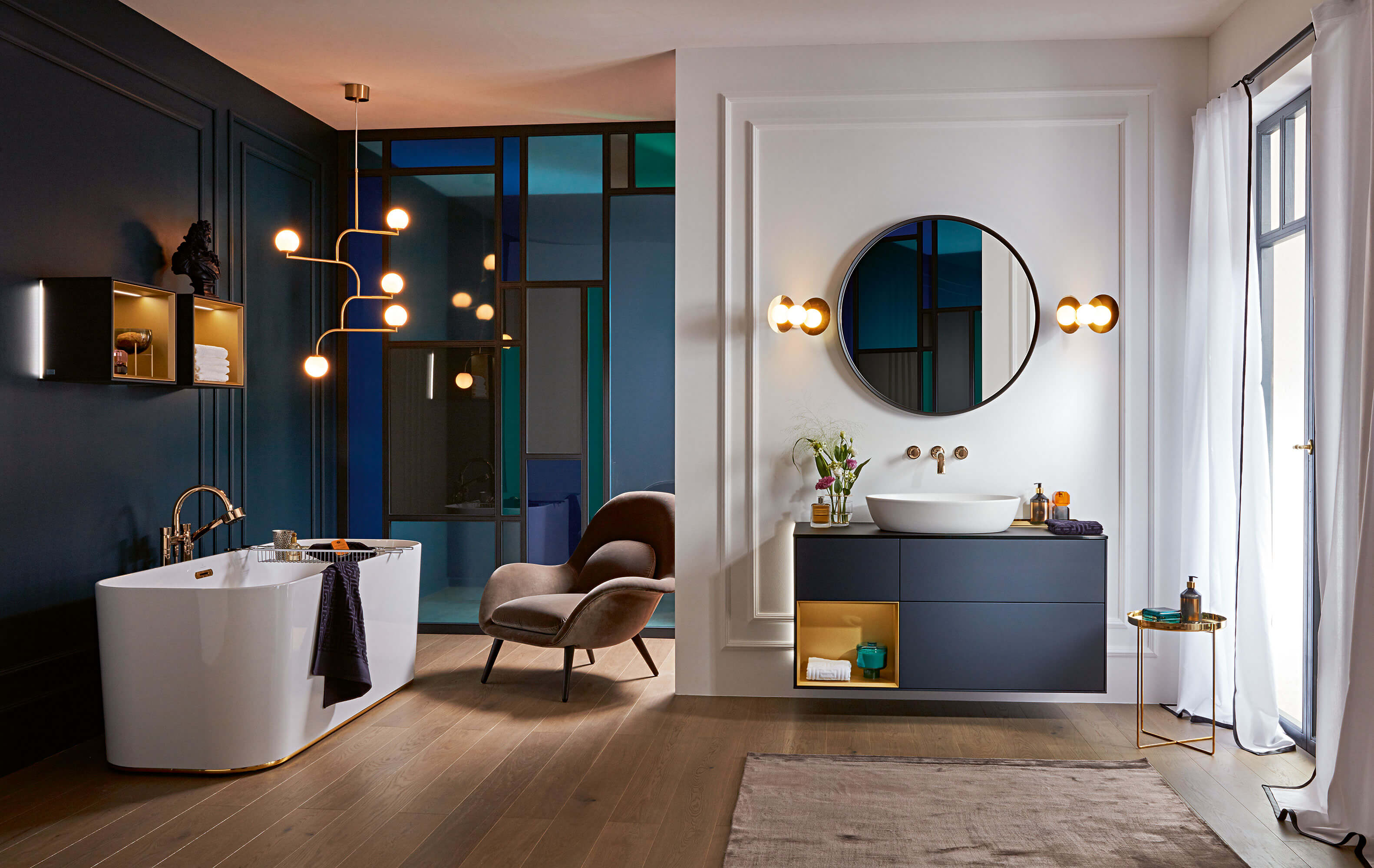 Finion bath in a classic bathroom with blue walls and wooden floors.