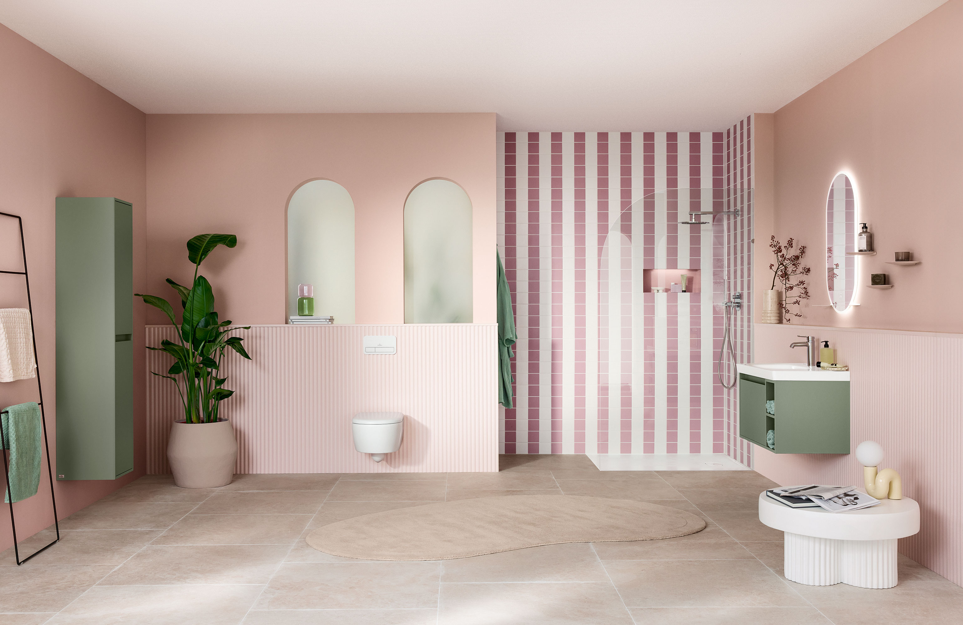 Moderne badeværelse med rosa vægge, stribet bruseområde, grønne detaljer, store spejle og en potteplante.