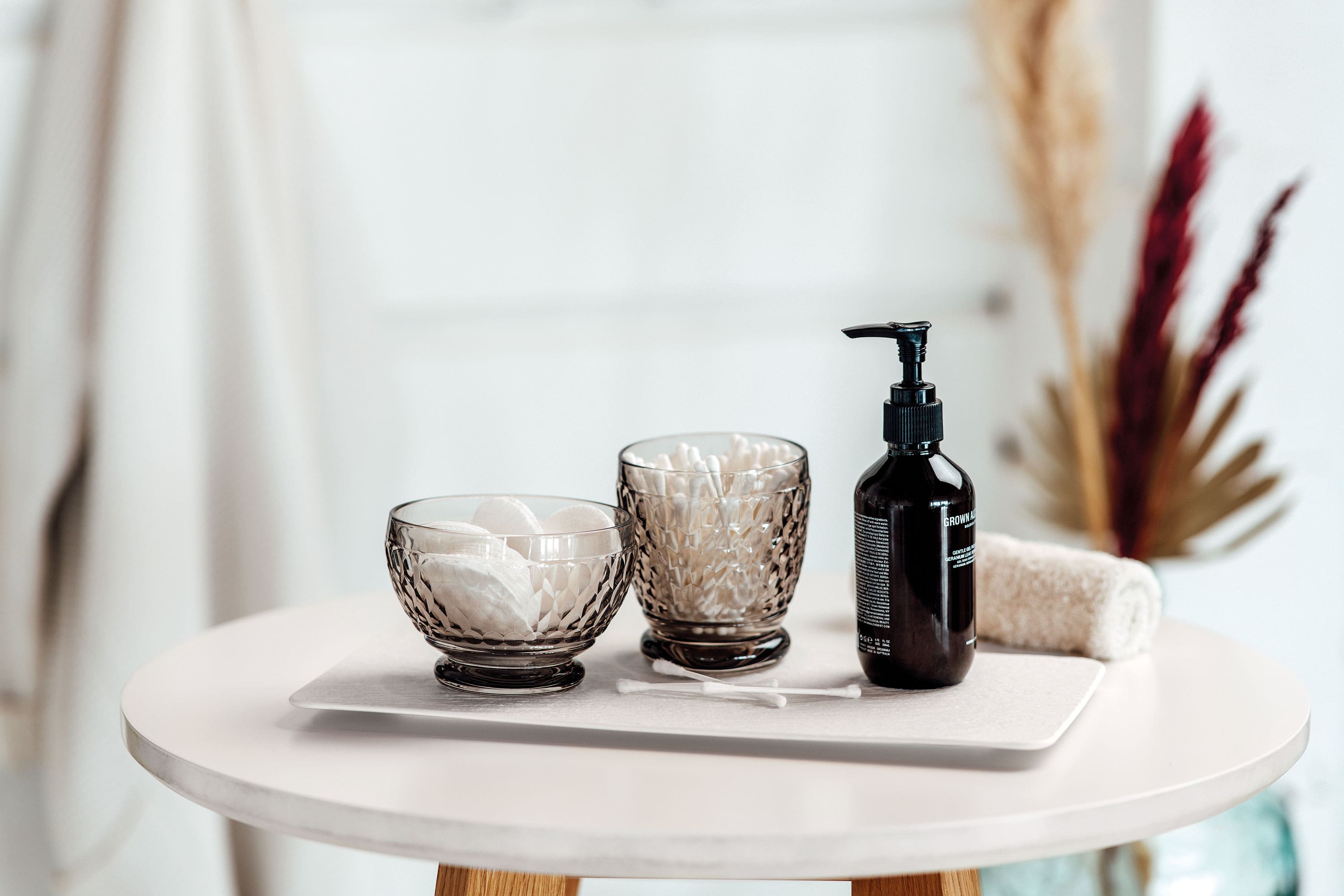 Two black Boston water glasses from Villeroy & Boch used as chic storage for cosmetic pads and cotton swabs.